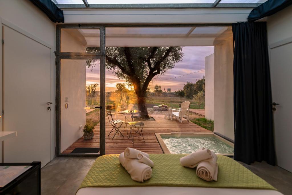 a bedroom with a view of a patio with a pool at Terecate Experimental Relais in Melendugno