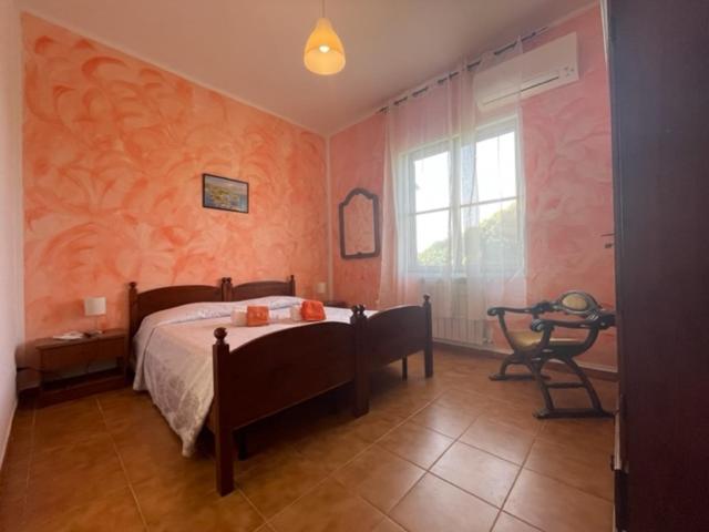 1 dormitorio con cama, mesa y ventana en Sa Covula, en Alghero