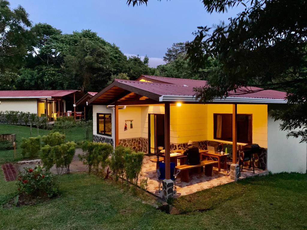 una pequeña casa amarilla con una mesa en un patio en Las Marias Mountain View Cottages, en Monteverde