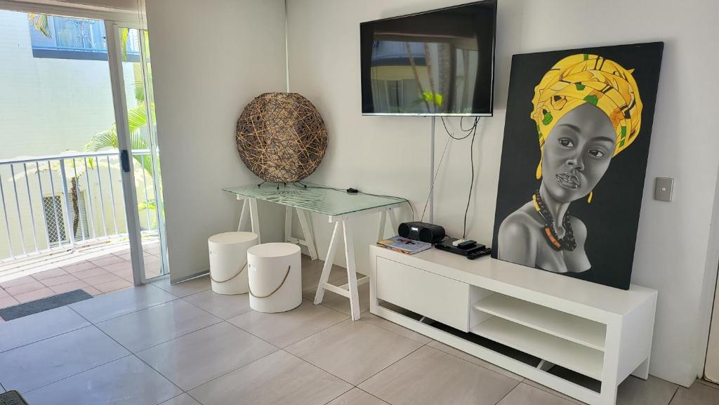a living room with a painting of a woman at Mooloolaba Beach Beachwalk in Mooloolaba