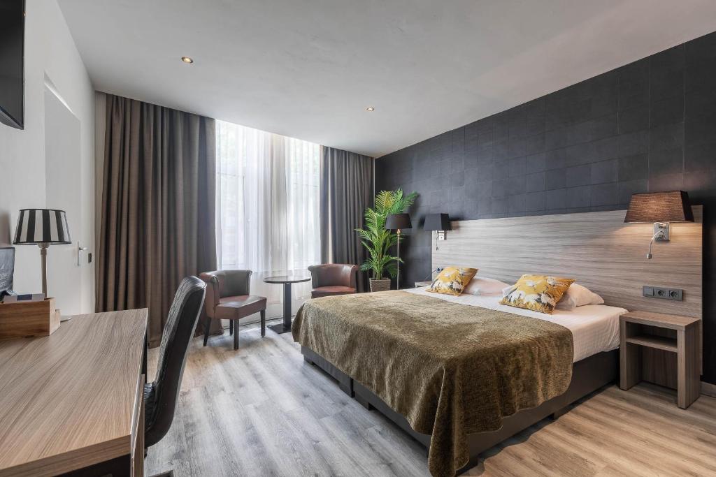a hotel room with a bed and a desk at Hotel Milano in Rotterdam