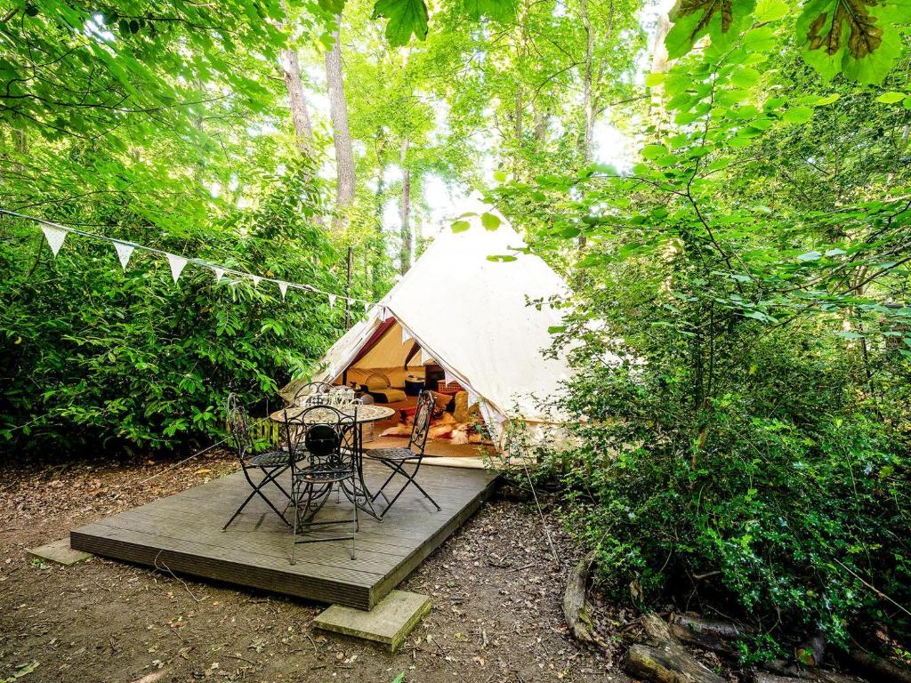 a tent with a table and chairs in a forest at Bedouin - Ukc5929 in Highclere