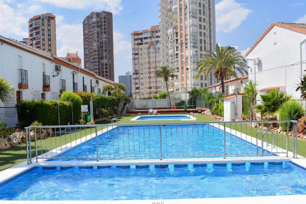 a swimming pool in a city with tall buildings at Cozy Tourist Bungalow in Benidorm