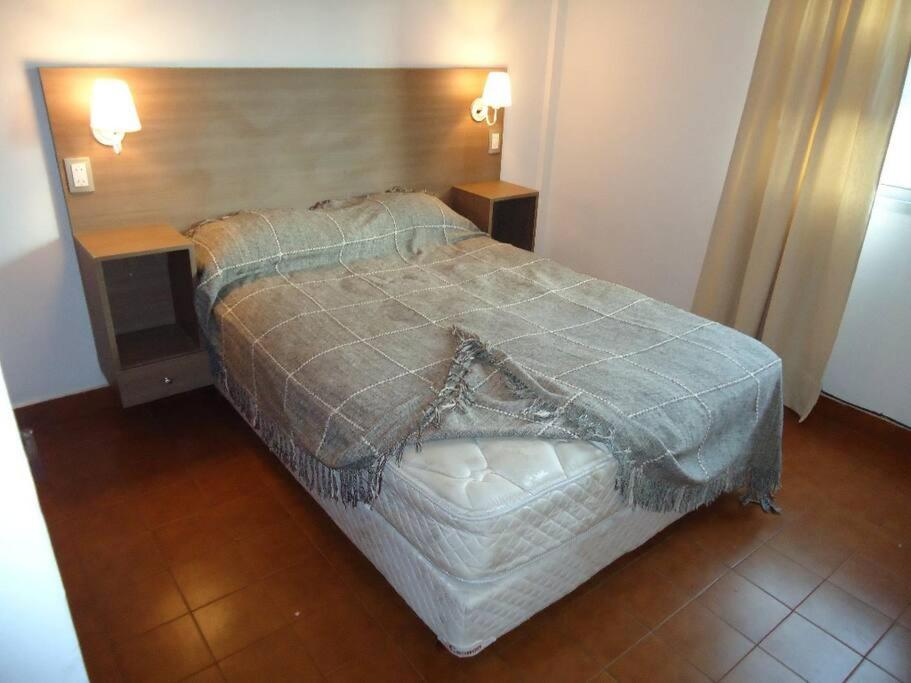 1 dormitorio con 1 cama y 2 mesitas de noche en Depto para 4 Pinamar centro NO Grupos jóvenes en Pinamar