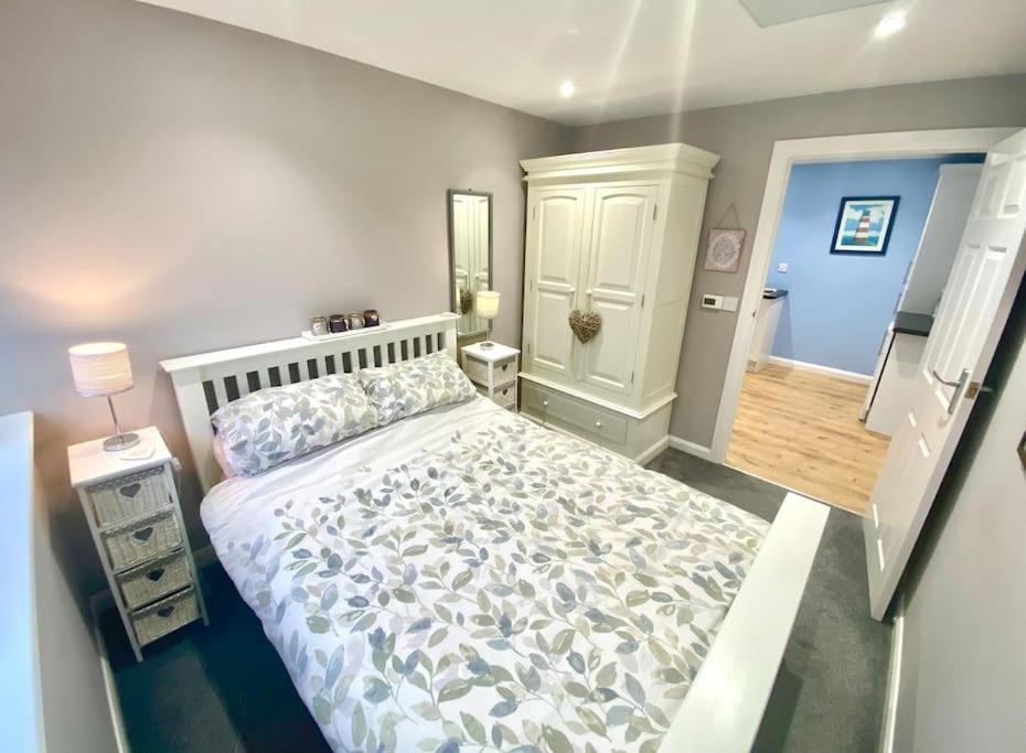 een slaapkamer met een groot bed in een kamer bij Modern Spacious Annex -Ground Floor in Brightlingsea