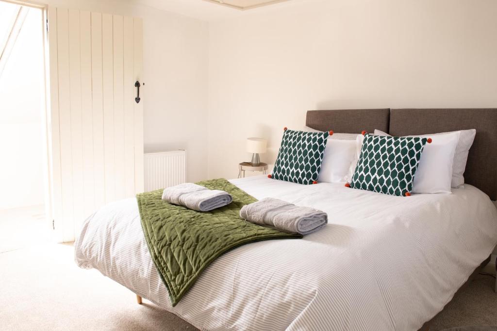 a bedroom with a large white bed with pillows at Charming 2BD Cottage wIth beautiful views nr Bath in Batheaston