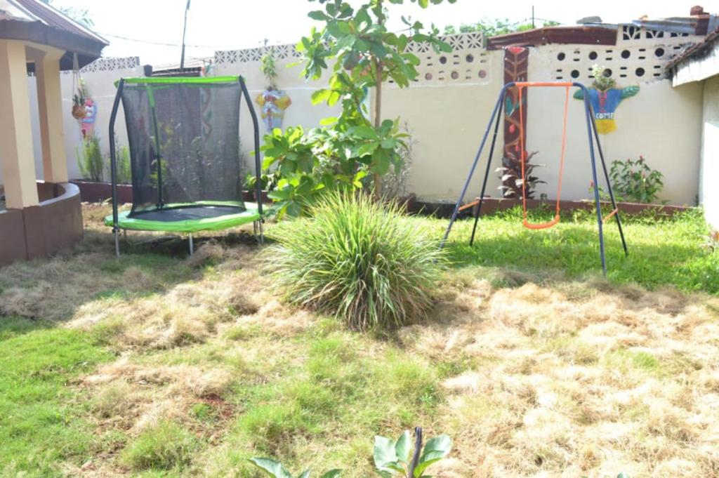 a backyard with a swing set in the yard at Fully air-condition 3Bed Villa - WiFi - hot water in Freetown