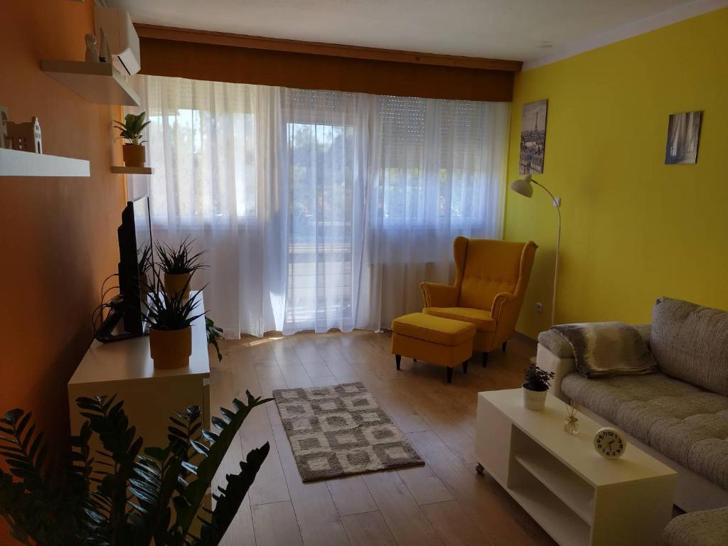 ein Wohnzimmer mit einem Sofa und einem Stuhl in der Unterkunft Pihenő Zug Apartman in Budapest