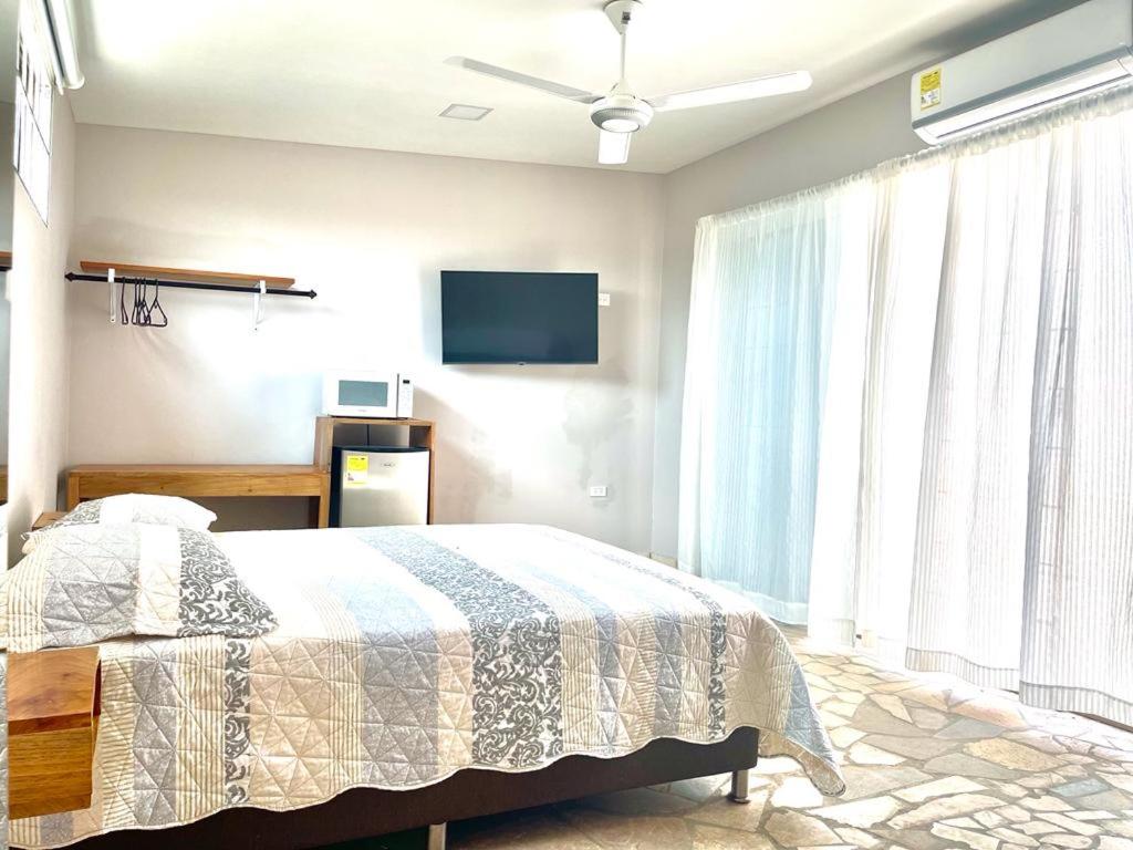um quarto com uma cama e uma televisão de ecrã plano em Casa Y em Tolú