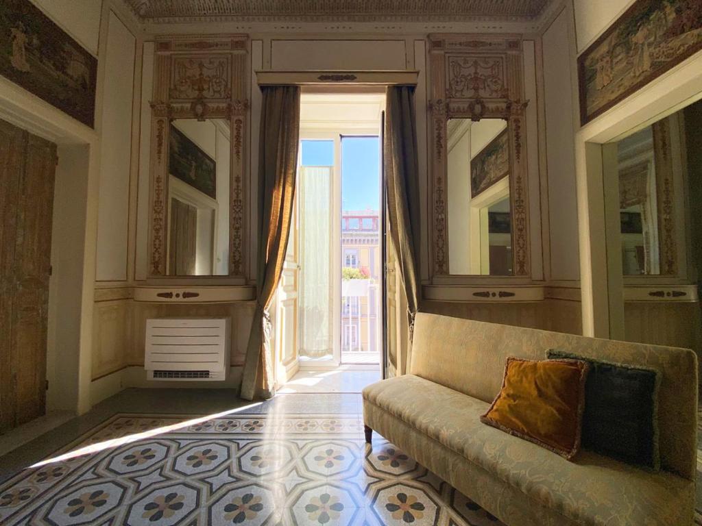 - un salon avec un canapé et une grande porte dans l'établissement MEA DOMUS Mergellina, à Naples