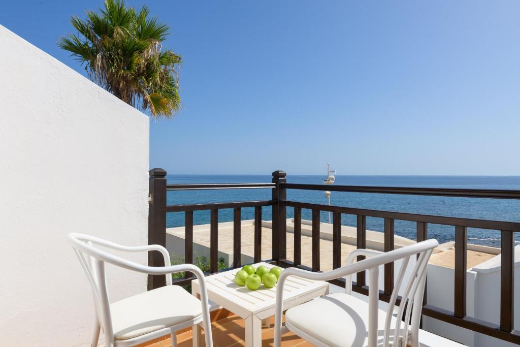 balcón con mesa, sillas y vistas al océano en Casa Maesa, en Playa Honda