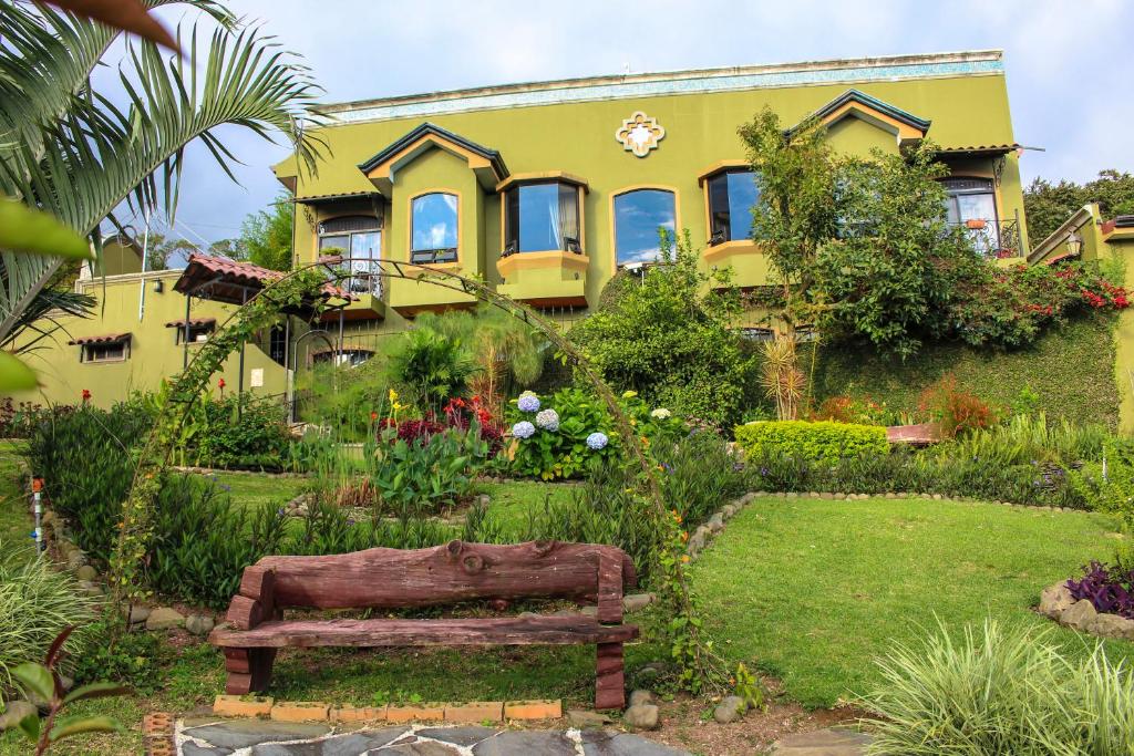 Casas del Toro في مونتيفيردي كوستاريكا: منزل اصفر امامه مقعد