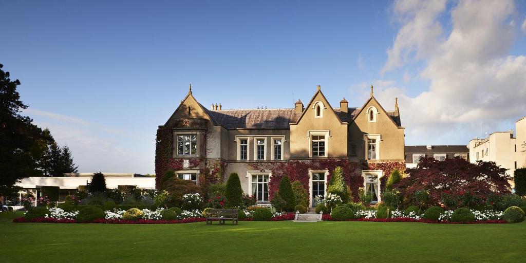 uma casa grande com um relvado verde em frente em Ballymascanlon Hotel and Golf Resort em Dundalk