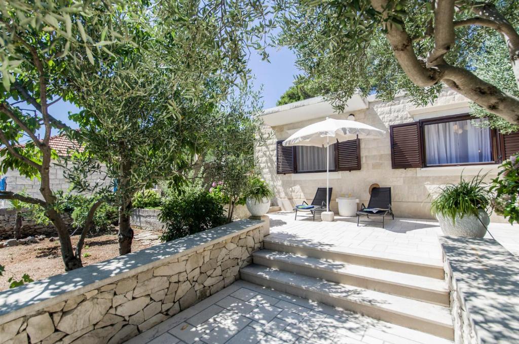a house with a stone retaining wall and stairs at House Vinka in Selca