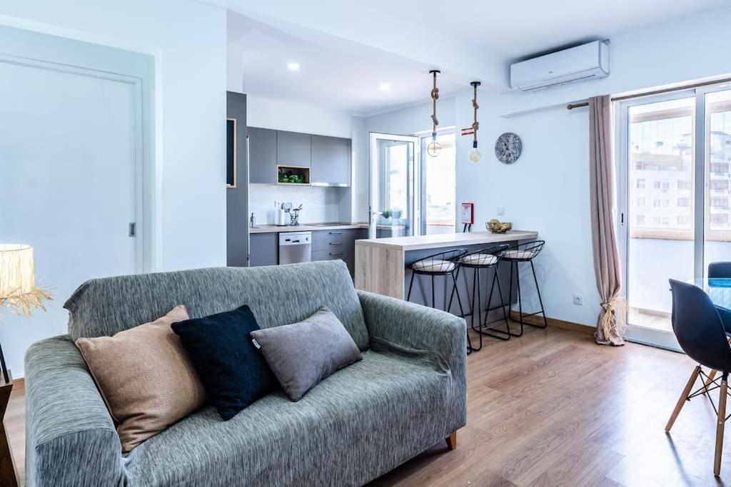 un soggiorno con divano e cucina di Faro Center with AC & WiFi a Faro