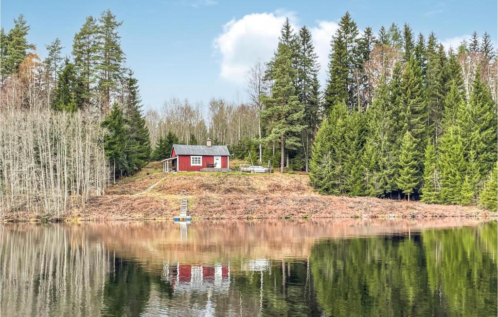 a red house on an island in the middle of a lake at Lovely Home In Rda With House Sea View in Råda