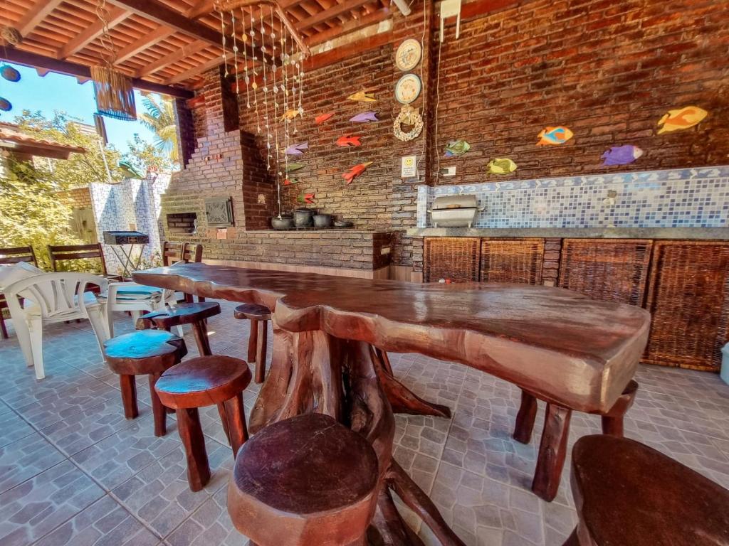 a large wooden table and chairs in a room at Aloha Beach Guest House in Maragogi