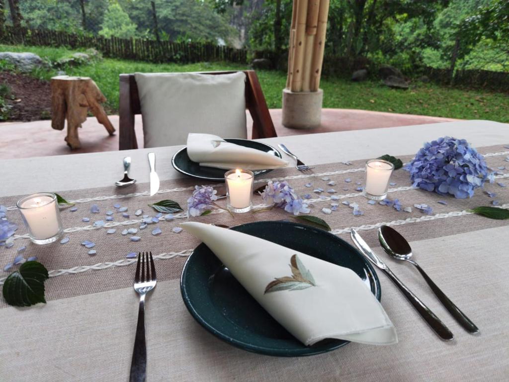 a table with a black plate with a napkin and candles at Espacio Pilam y cascada privada! in Xico