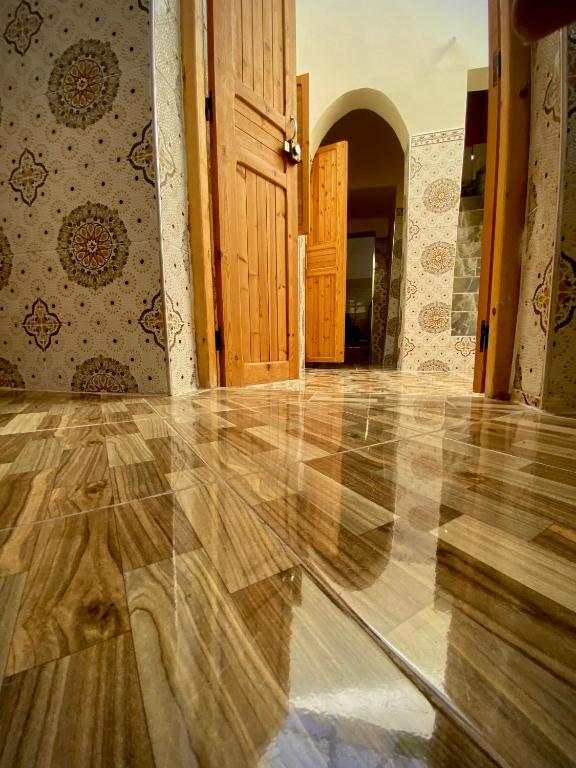 een lege kamer met een houten vloer en een deur bij Dar Haniya in Rabat