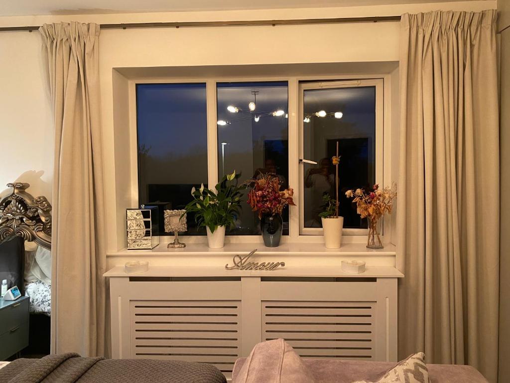 ein Fenster mit Blumen auf einem Zimmer in der Unterkunft Niv’s Home away from Home in Kempston