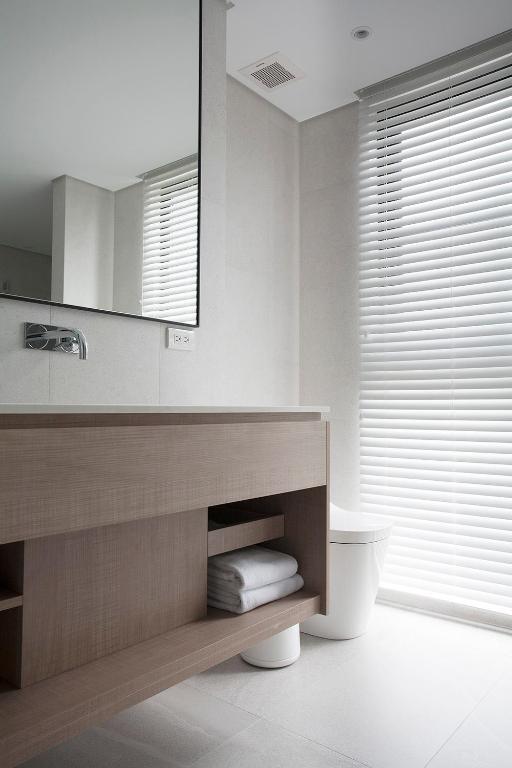 a bathroom with a sink and a toilet and a mirror at Manho Hotel in Taichung