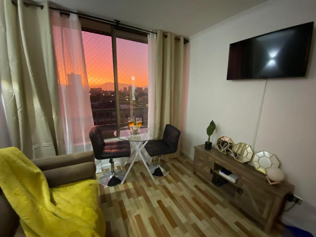 uma sala de estar com uma mesa e uma janela com vista em Departamento Céntrico em Santiago