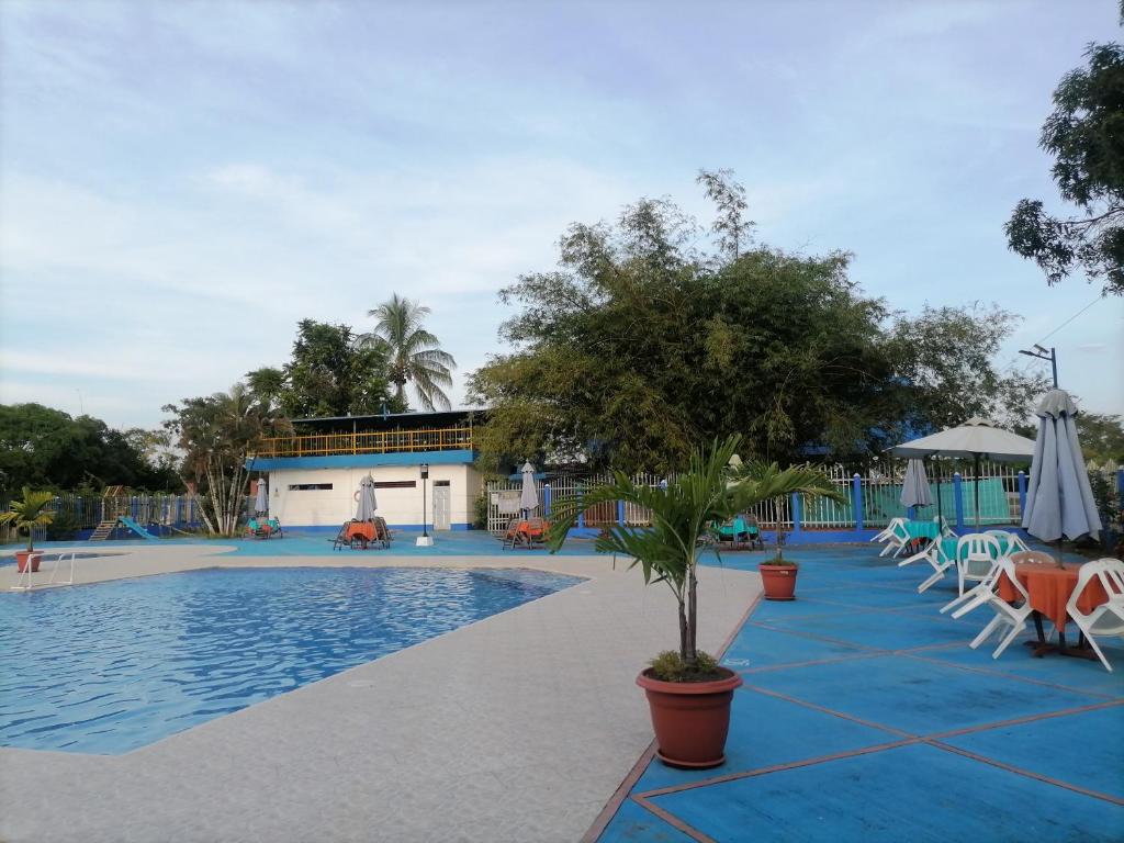 比亞維森西奧的住宿－Hotel campestre la Maria，一个带桌椅的度假村游泳池
