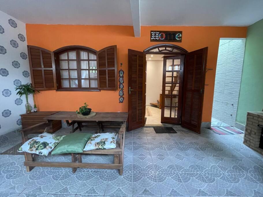 um quarto com uma mesa de madeira e algumas portas em Casa Duplex em Cabo Frio - pertinho de tudo! em Cabo Frio