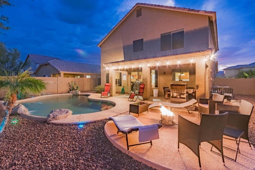 a house with a swimming pool in the yard at Desert Oasis Amazing Pool Waterfall Firepit Office in Casa Grande