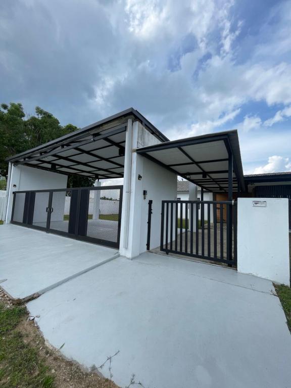 a garage with a metal roof and a gate at Nur Villa Sg Soi Musslimm Only in Kuantan