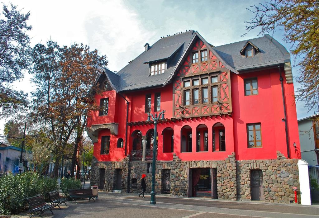 a red brick building with a red fire hydrant at Hotel Boutique Castillo Rojo in Santiago
