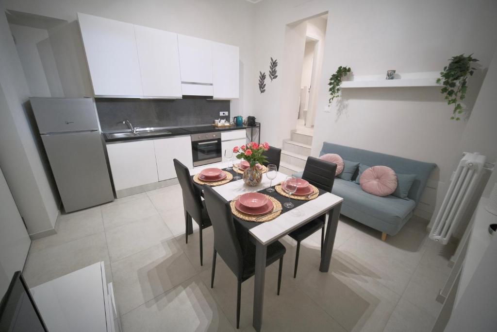 kuchnia i salon ze stołem i krzesłami w obiekcie Appartamento moderno ❴ 300 mt. da PORTA NUOVA ❵ w Turynie