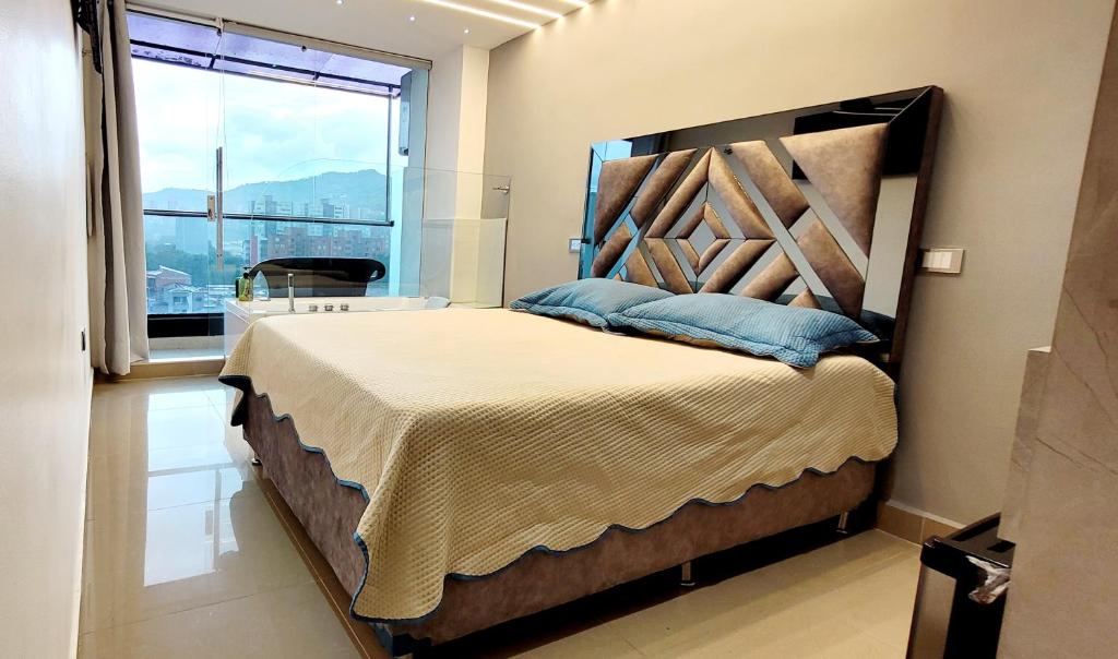 1 dormitorio con 1 cama grande y ventana grande en 901 Loft con jacuzzi privado cerca al barrio Laureles, en Medellín