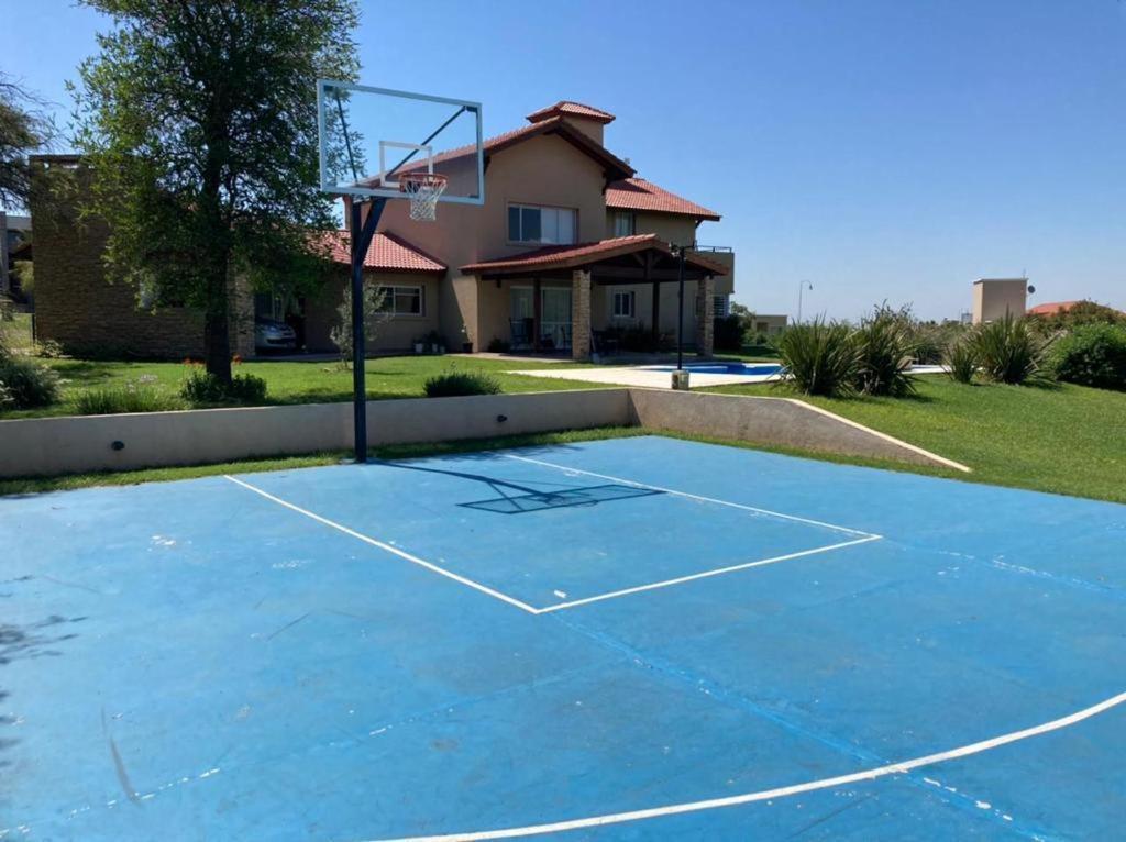 a basketball court in front of a house at Casa con vista a las sierras de Cordoba in Malagueño