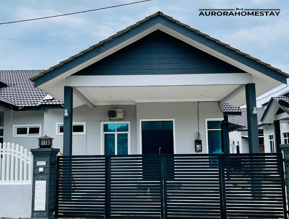 una casa con una puerta azul y una valla en Aurora Homes en Marang