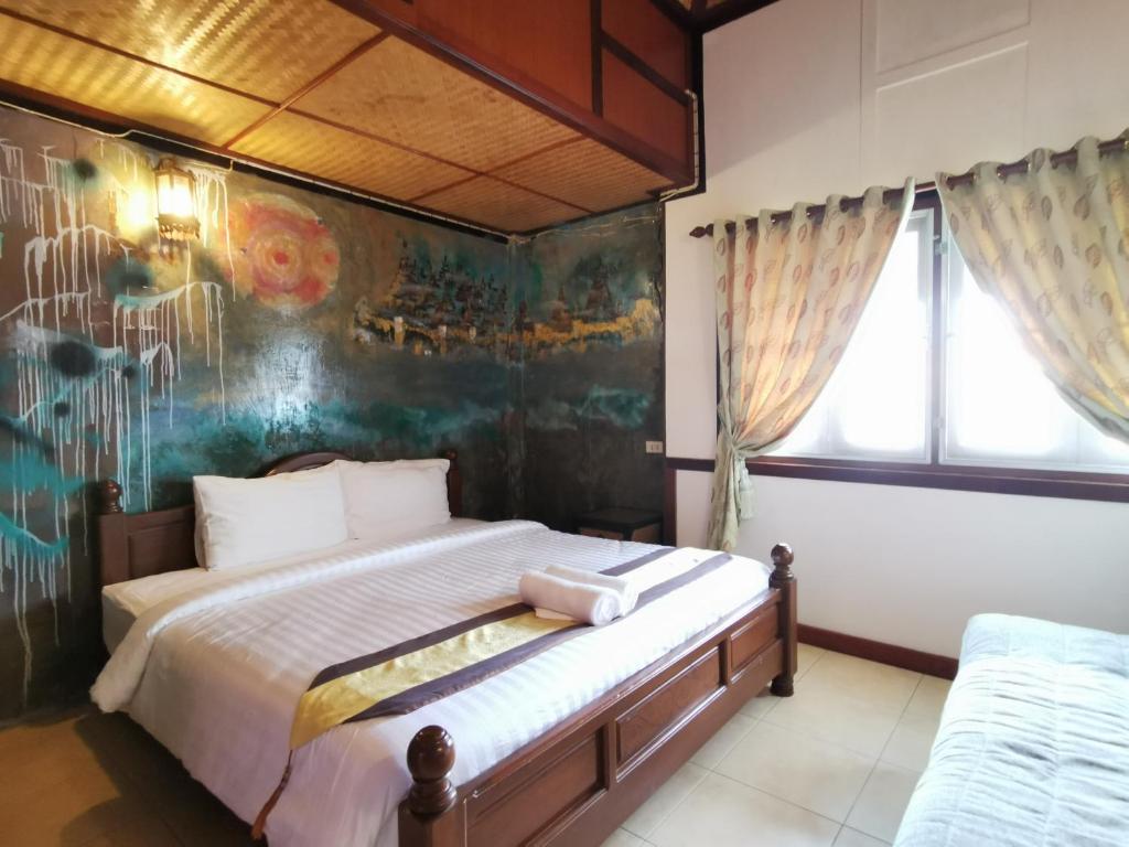 バンコクにあるSri Ayuttaya Guesthouseのベッドルーム1室(壁に絵画が描かれたベッド1台付)
