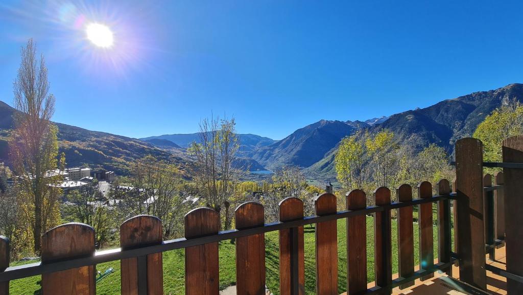 una valla de madera con las montañas en el fondo en tuhogarencerler,sol y vistas en Cerler