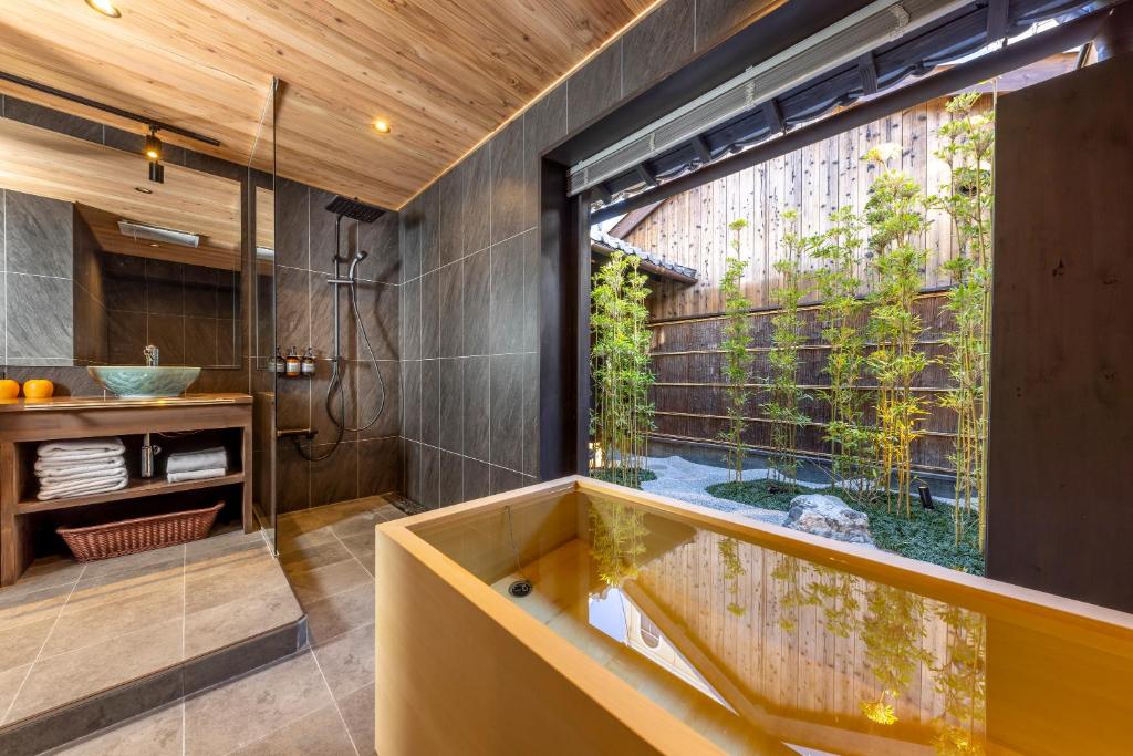 a bathroom with a tub and a large window at GION KAWASEMI in Kyoto
