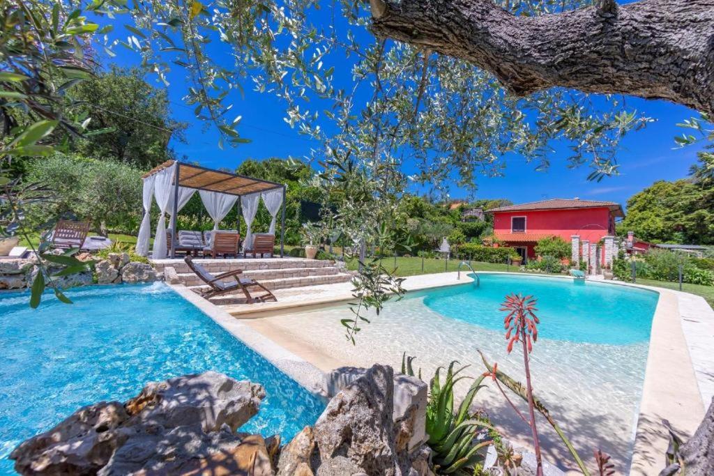 una piscina con cenador y una casa en La Casa Fra gli Ulivi luxury apartments with pool near Cinque Terre and Tuscany, en Monte Marcello