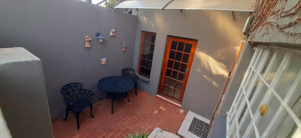a patio with a table and chairs and a door at Cozy 1 Bedroom Cottage in Johannesburg