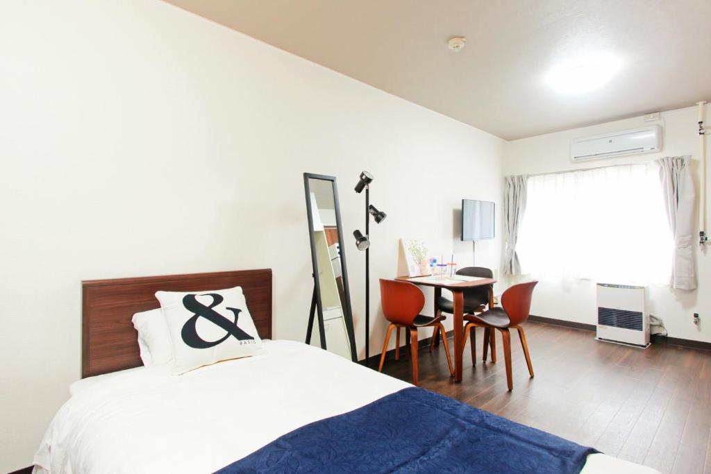 a bedroom with a bed and a table and chairs at HEIGHTS N7 in Kita-rokujō