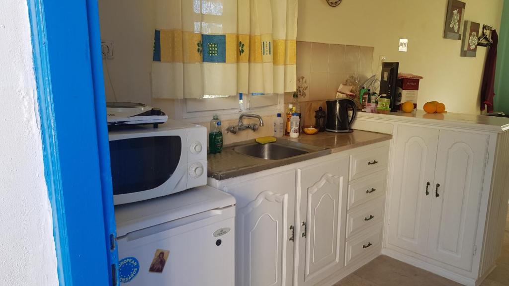 a kitchen with a sink and a microwave at Irene's Studio in Kalymnos