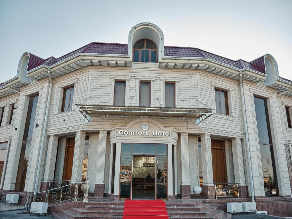 un edificio con una alfombra roja delante de él en Comfort Hotel Samarkand, en Samarkand