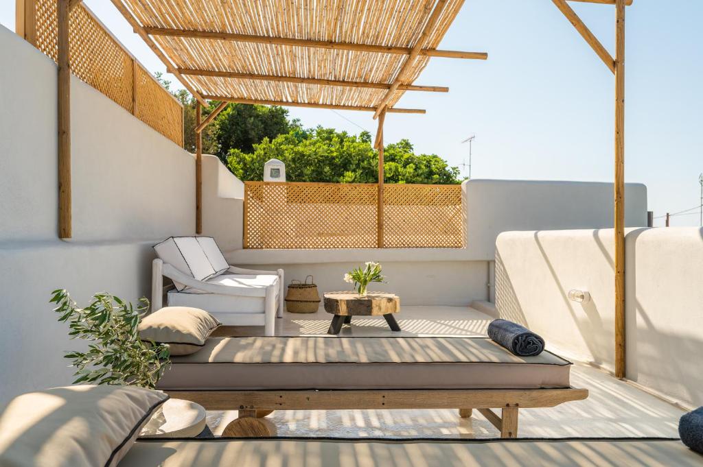 a balcony with a bed and a chair and a table at Icos village house in Hersonissos