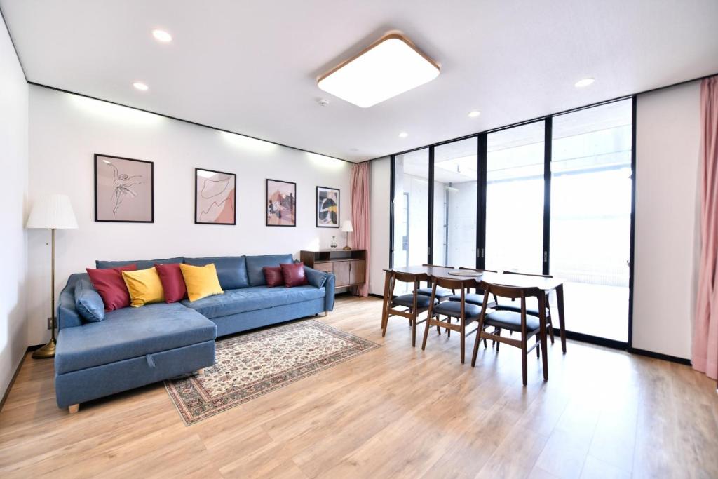 uma sala de estar com um sofá azul e uma mesa em BRUCE HOUSE - Vacation STAY 9370 em Izumi-Sano