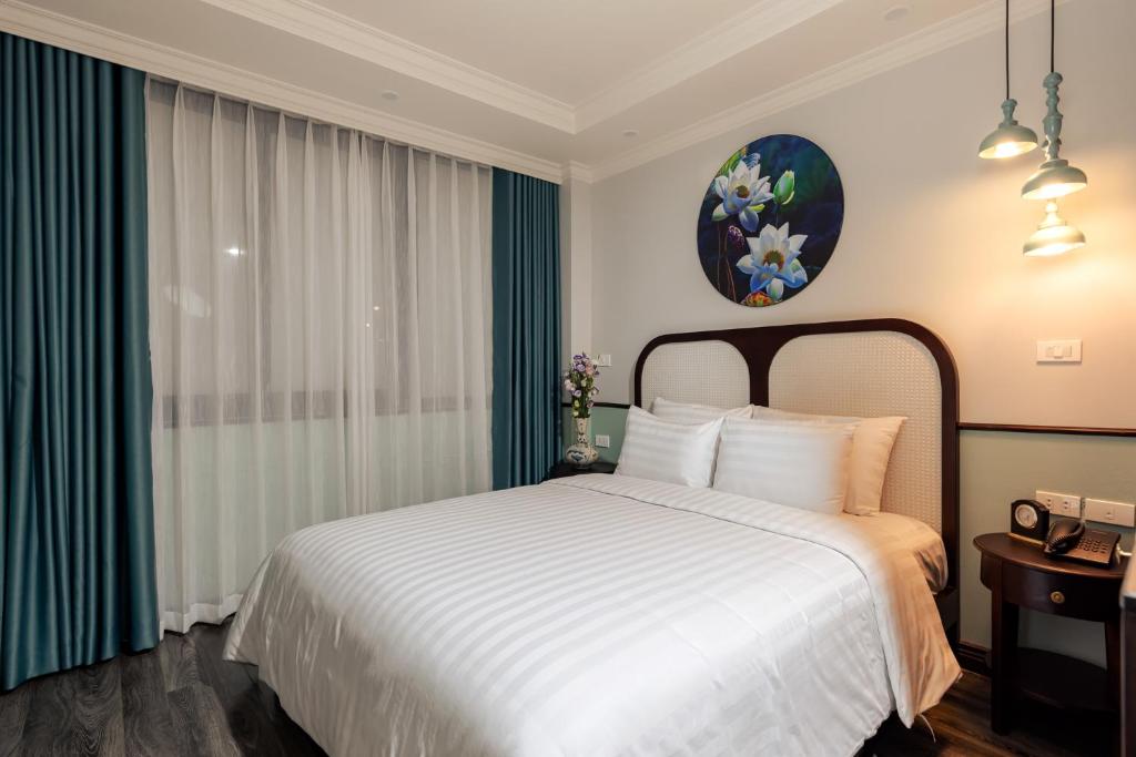 Postel nebo postele na pokoji v ubytování Hanoi Golden Lotus Aman Hotel