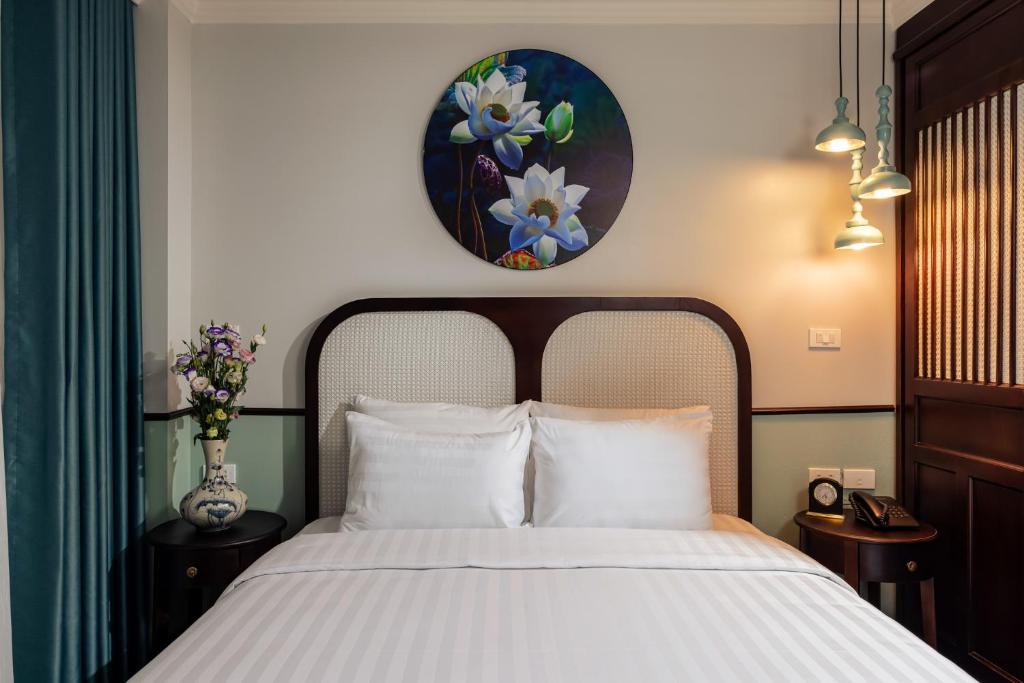 Postel nebo postele na pokoji v ubytování Hanoi Golden Lotus Aman Hotel