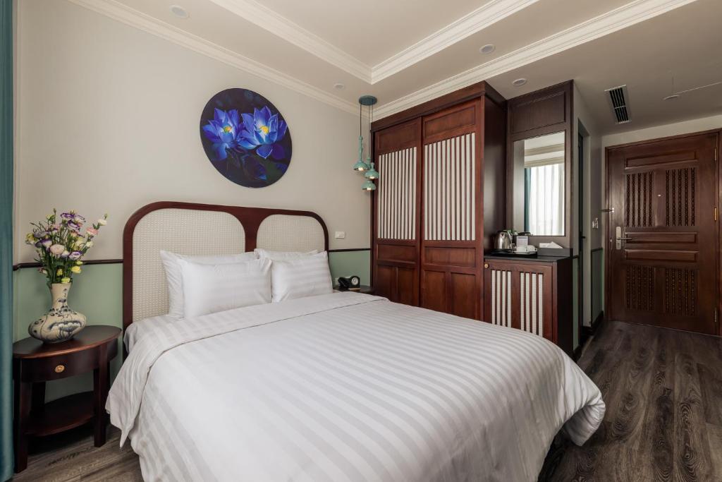 Postel nebo postele na pokoji v ubytování Hanoi Golden Lotus Aman Hotel