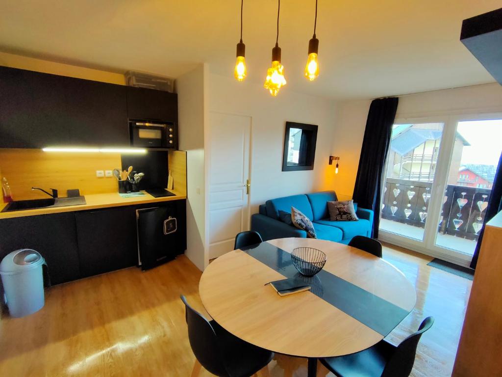 sala de estar con mesa y sofá azul en Risoul Appartement 2 chambres Piscine Balcons de Sirius, en Risoul