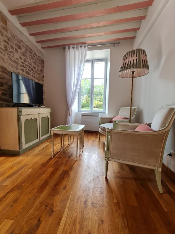 - un salon avec un canapé et une table dans l'établissement Le Moulin de L'O - L'Orle Rose, à Semur-en-Auxois